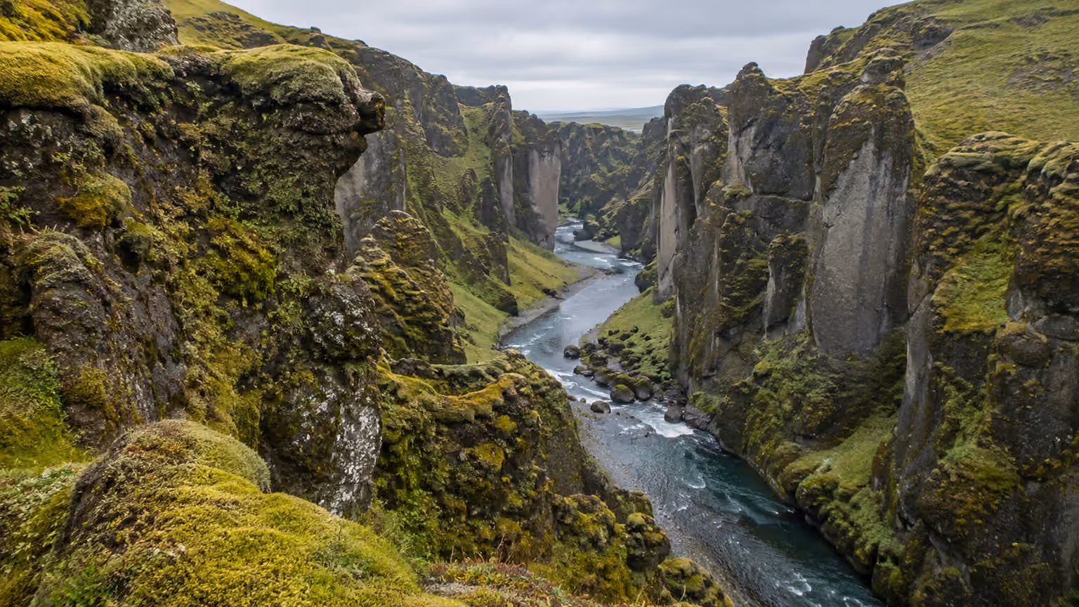 A view of mossy Icelandic canyon rocks and a narrow river bend within Fjadrargljufur
