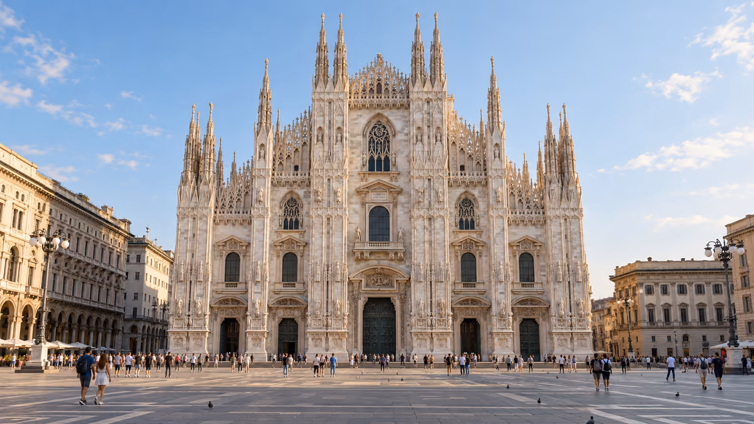 The marble facade and spires of Milan Cathedral overlooking the open cathedral square